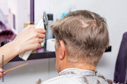 Stylish hair styling for an elderly man in hairdressing salon