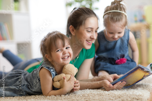 Young woman with children kids reading a book