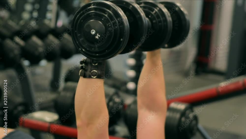 Close up of mans hands, raising and lowering dumbbells in fitness club. Dumbbell exercises. Exercising male fitness model working out in gym. Close up of mans hands, raising and lowering dumbbells in fitness club. Dumbbell exercises. Exercising male fitness model working out in gym.