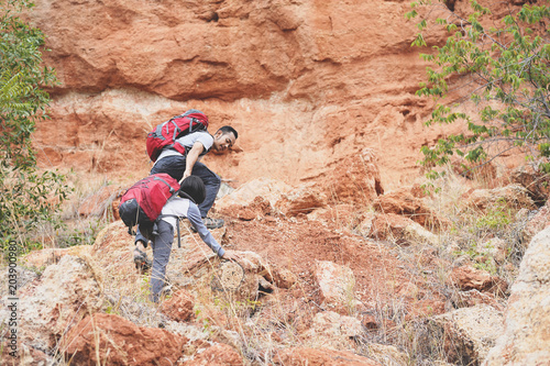 Father and daughter hiking climbing in mountains together success idea concept 3