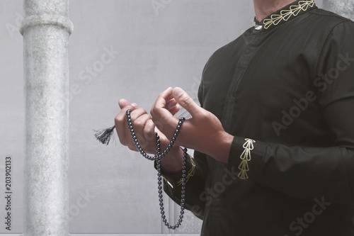 Muslim man praying with prayer beads