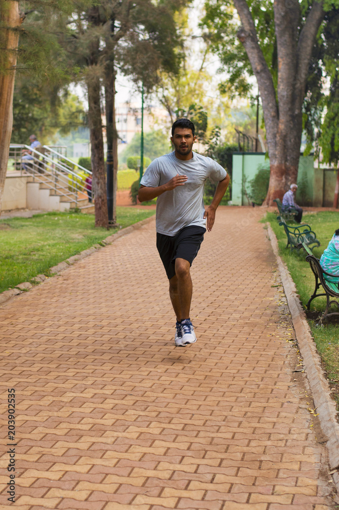 Young guy jogging on a path in a park