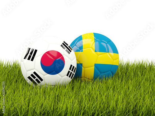 South Korea vs Sweden. Soccer concept. Footballs with flags on green grass