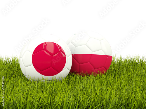 Japan vs Poland. Soccer concept. Footballs with flags on green grass