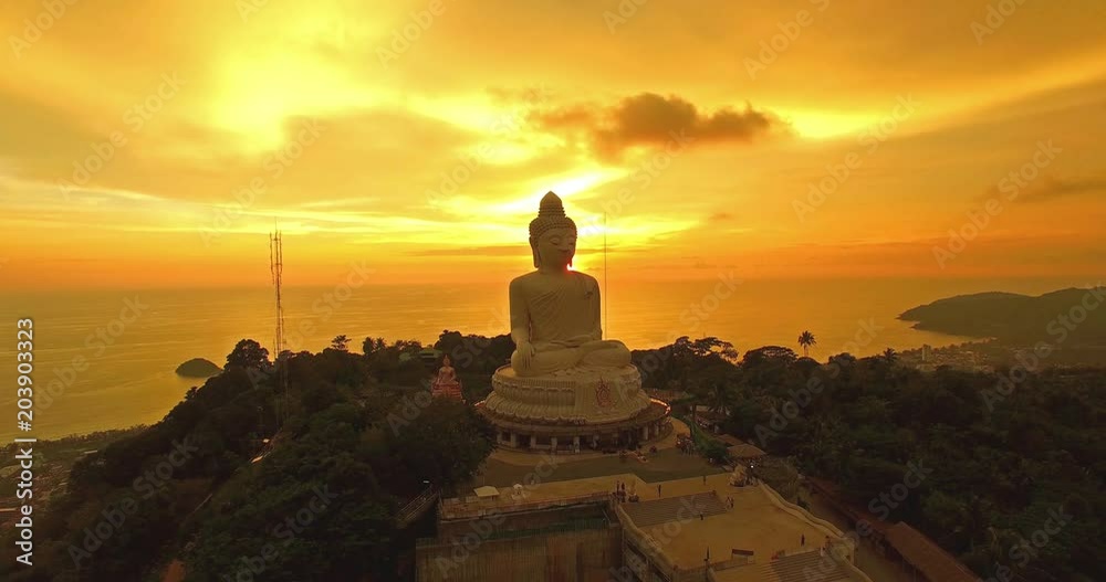 aerial view the white big Buddha statue on the high mountain in sunset time. Phuket big Buddha on hilltop can see around Phuket island behind Phuket big Buddha is Karon gulf in front is Chalong gulf. aerial view the white big Buddha statue on the high mountain in sunset time. Phuket big Buddha on hilltop can see around Phuket island behind Phuket big Buddha is Karon gulf in front is Chalong gulf.