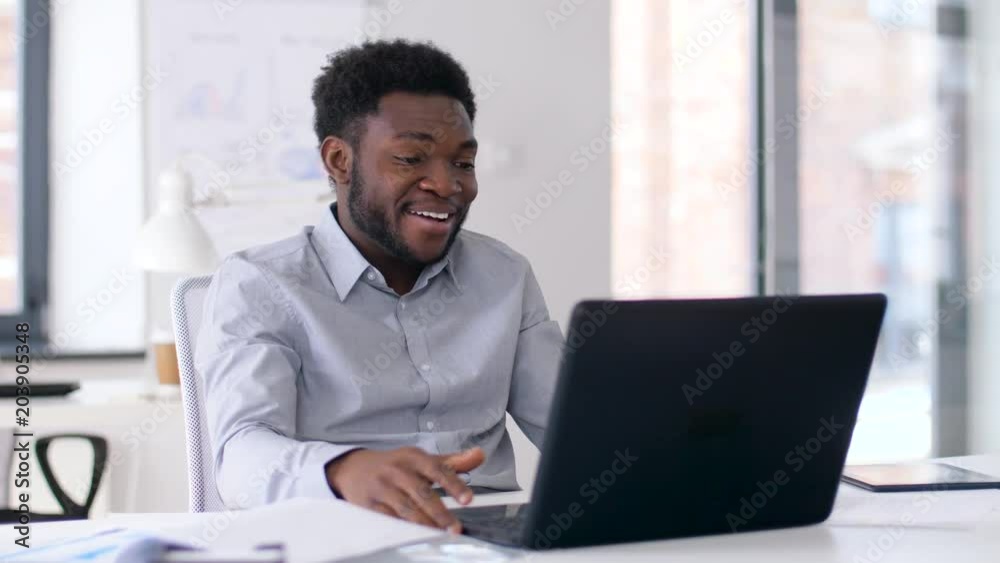 business, technology and communication concept - happy smiling african american businessman having video chat on laptop computer at office business, technology and communication concept - happy smiling african american businessman having video chat on laptop computer at office