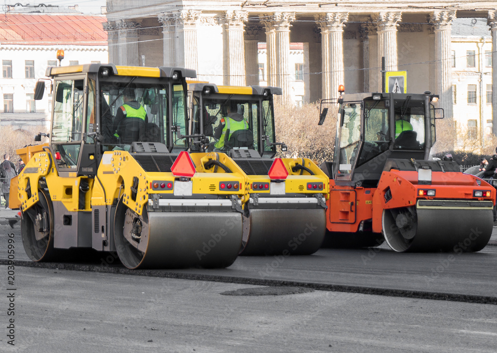 Road re-construction. Road rollers stacking hot asphalt.