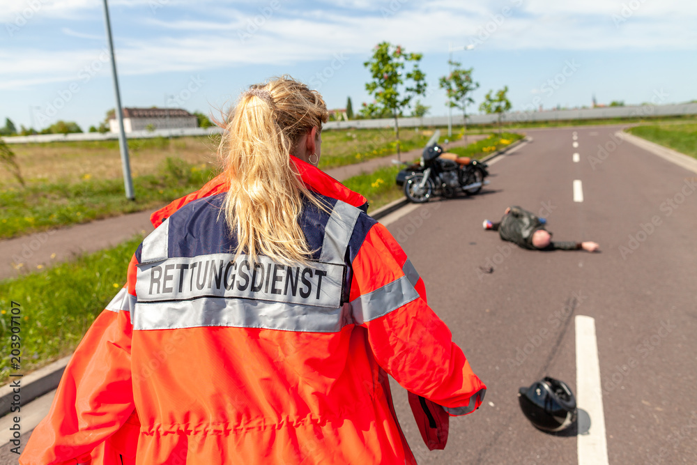 A german paramedic helps an injured motorcyclist. Rettungsdienst is the  german word for ambulance service. Stock Photo