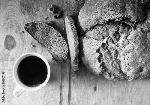 Loaf of homemade freshly baked bread and cup of coffee on the table
