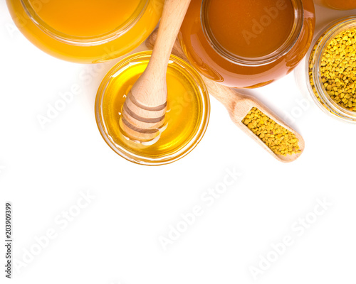 honey dipper and honey in jar on white background