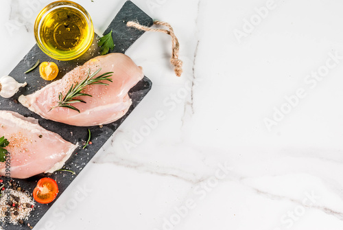 Schilderij op canvas Raw chicken breast filet meat with spices and olive oil top view copy space