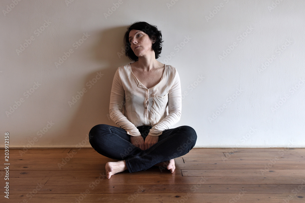 a sad woman on the floor of her house a sad woman on the floor of her house
