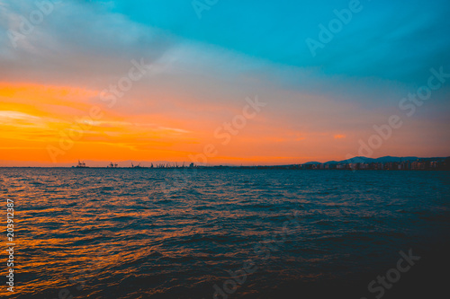 Vivid tropical ocean sunset with orange sky