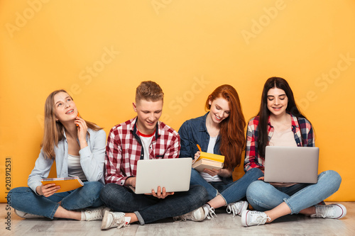 Group of young happy school friends doing homework
