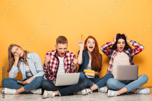 Group of excited school friends doing homework