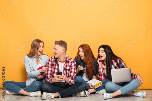 Group of young positive school friends doing homework