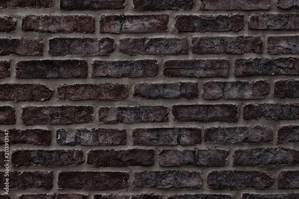 Fototapeta premium Dark brown rough brick wall close-up texture for background