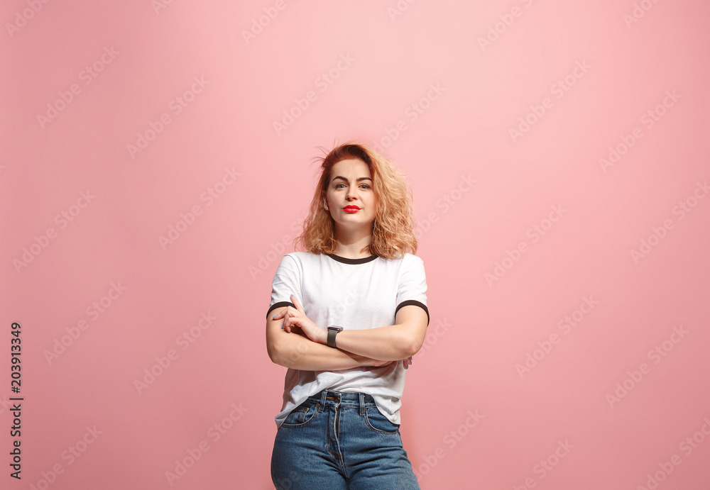 The serious business woman standing and looking at camera against pink background. The serious business woman standing and looking at camera against pink background.