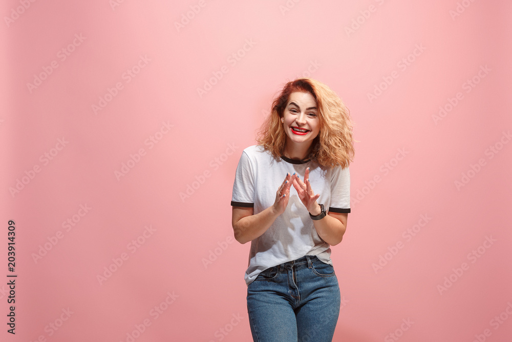 The happy business woman standing and smiling against pink background. The happy business woman standing and smiling against pink background.