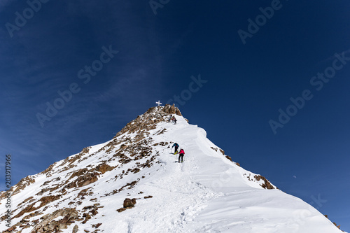 Wildspitze mit Kreuz im Winter unter blauem Himmel