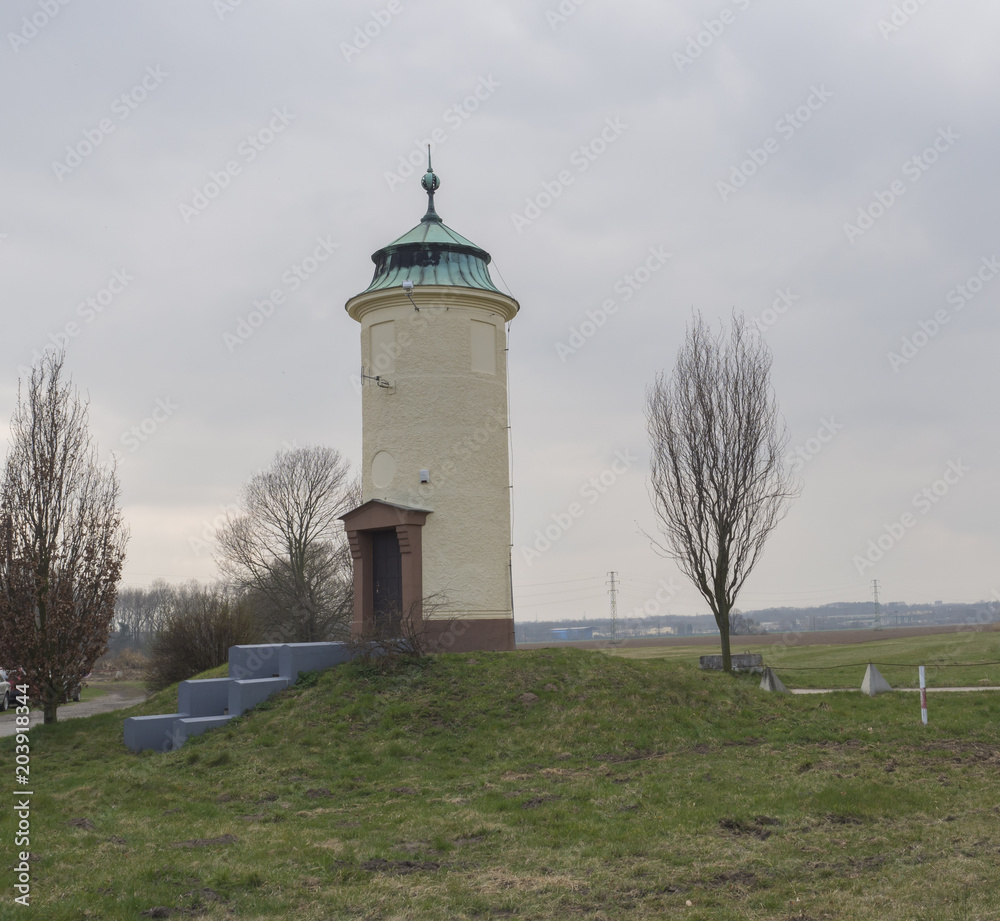 old historical rounded water tower near elbe river, Czech Republic, green grass, blue sky, early spring