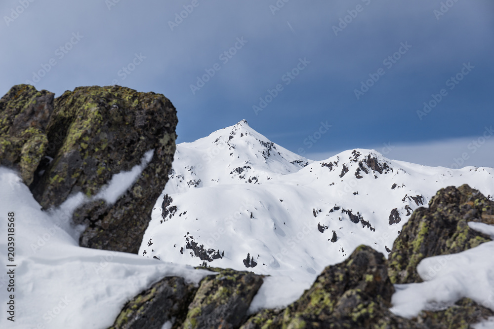 Felse ragen aus dem Boden mit Blick auf den Gipfel im Winter