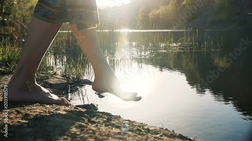 woman walks into the water, legs close up photo