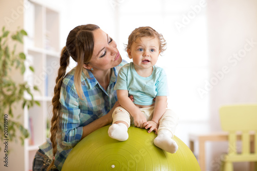 kid boy and mother doing gy...