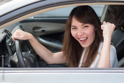 excited woman driver driving personal car  portrait of happy, smiling, excited asian woman driver driving her car, right hand driving or right hand traffic style  30s adult asian Chinese woman model © 9nong