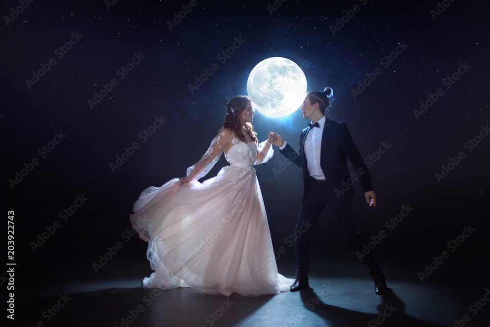 Mysterious and romantic meeting, the bride and groom under the moon. Hugs together. Mixed media Mysterious and romantic meeting, the bride and groom under the moon. Hugs together. Mixed media