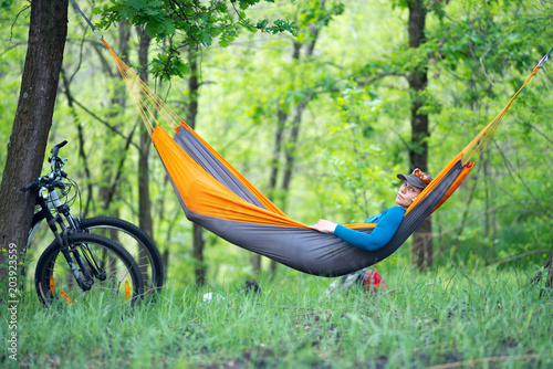 Woman relaxes in a hammock after biking