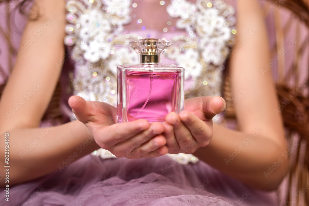 Teen girl with parfume bottle in her hands Stock Photo | Adobe Stock