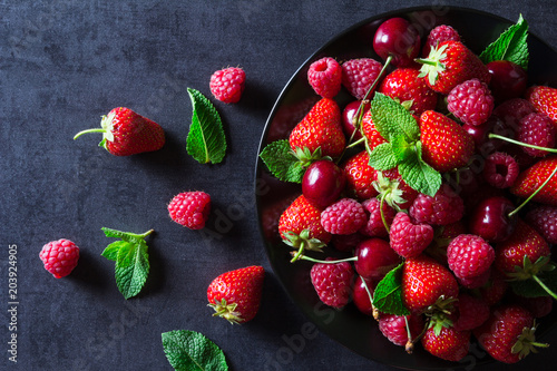 Fresh red ripe berries on black plate