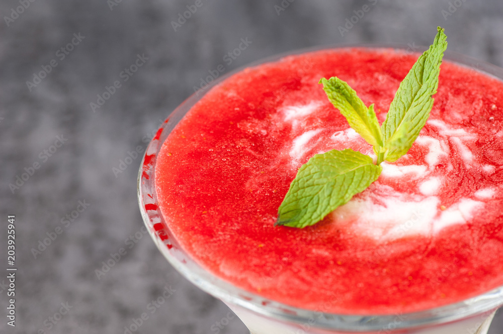 fruit smoothie with a petal in a glass vase on a gray surface. fruit smoothie with a petal in a glass vase on a gray surface.