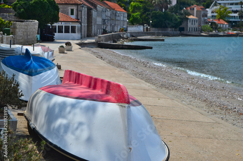 Two boats, red and blue, on the beach by the Adriatic sea in Croatia
