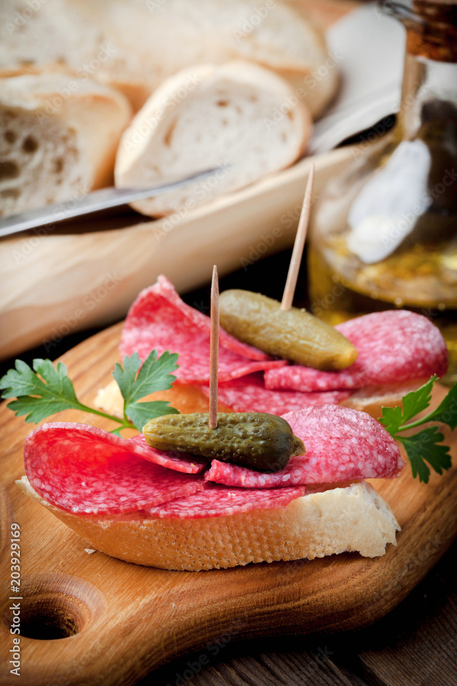 Tapas with sliced sausage, salami, olives and parsley.