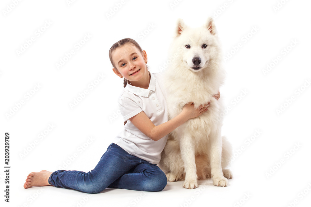 Happy child with white dog. Portrait girl with pet. Smilyng Samoyed Laika dog.