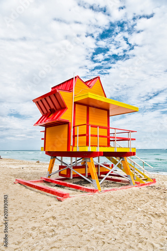 Lifeguard house on sand beach in miami, usa. Tower for rescue baywatch in typical art deco style. Wooden house on ocean shore on cloudy sky. Summer vacation concept. Public guarding and safety