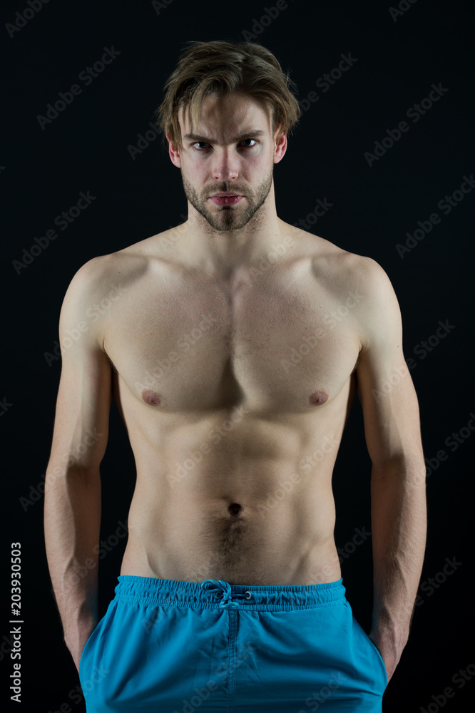 Sportsman with six pack and ab muscles. Macho with sexy torso and chest. Man bodybuilder with fit body. Training and workout activity in gym. Sport or fitness and bodycare concept