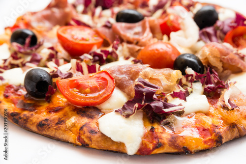 Pizza with ham, tomatoes, radicchio, black olives and mozzarella 