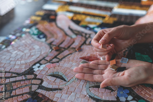 Female hands with mosaic photo