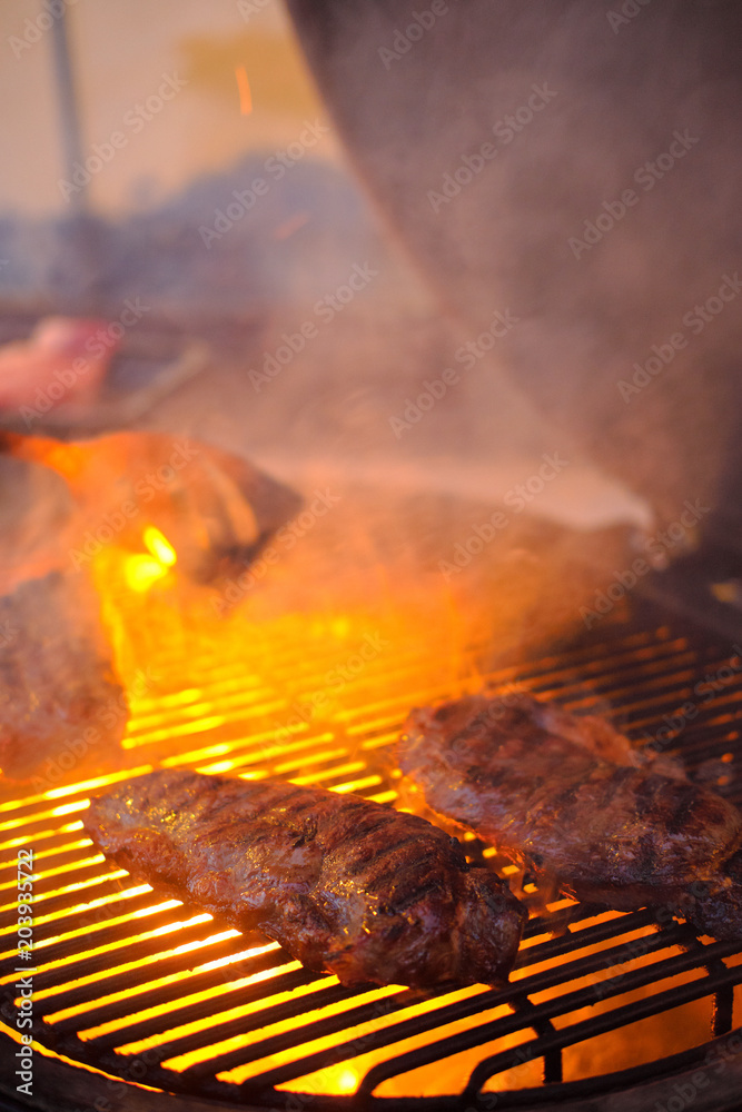 Delicious grilled beef steak with fire on background