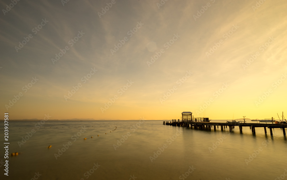 scenic of sunrise and ocean dock in the sea