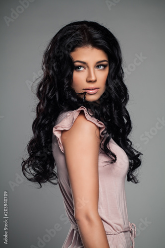 Fashion Portrait of Stylish Brunette Woman in Pink Dress. Elegant Female Model with Curly Hairstyle