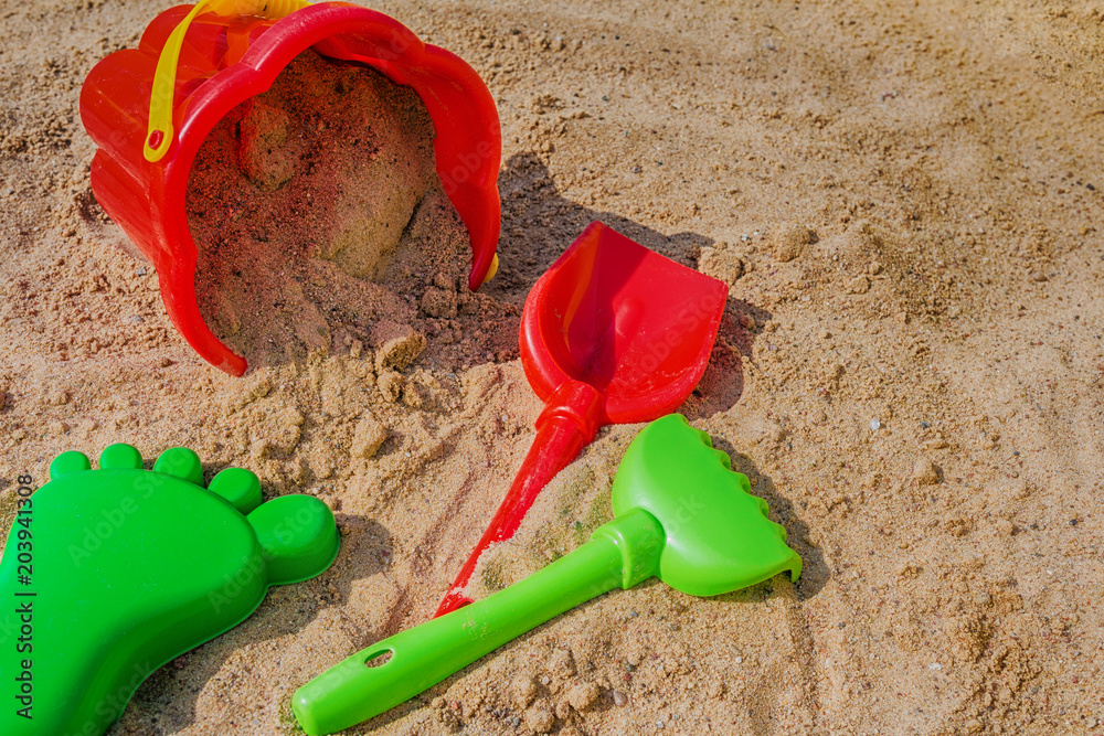 children's sandbox and colorful plastic toys pail bucket and rake for playing outdoors in the summer day concept of development and recreation of children with copy space children's sandbox and colorful plastic toys pail bucket and rake for playing outdoors in the summer day concept of development and recreation of children with copy space