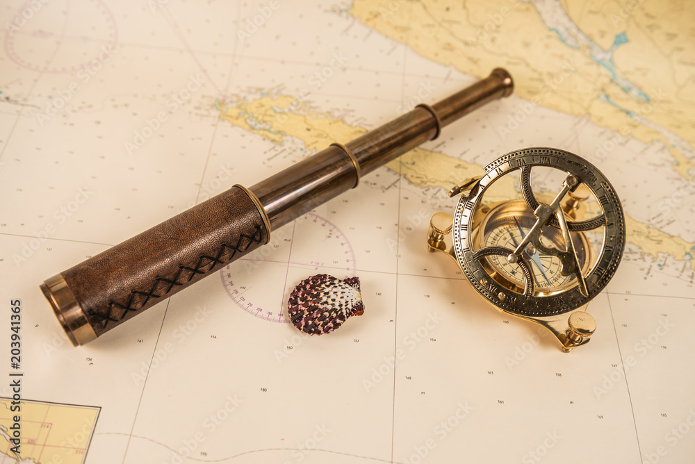 Antikes Fernglas und Kompass auf einer Seekarte
