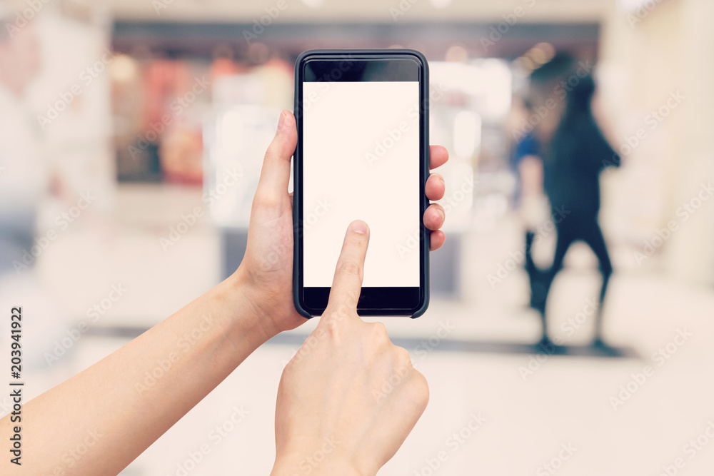 Hand woman holding and using phone with blurred background in shopping mall. Hand woman holding and using phone with blurred background in shopping mall.