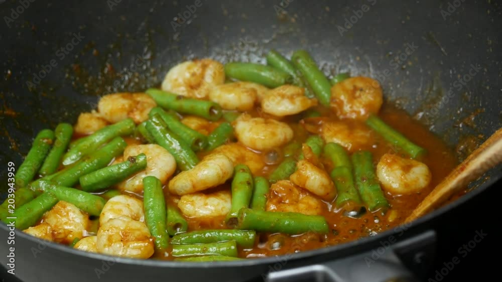 pour drinking water into the pan, stir fried shrimp , yard long beans, the spices , curry paste , food palm oil together in the black teflon pan and with wooden turner. pour drinking water into the pan, stir fried shrimp , yard long beans, the spices , curry paste , food palm oil together in the black teflon pan and with wooden turner.