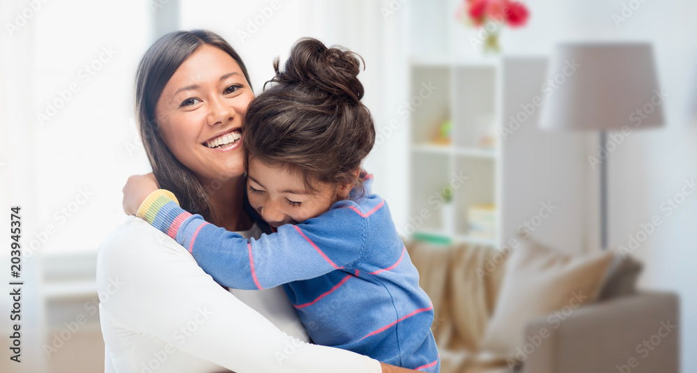 family, motherhood and people concept - happy mother and daughter hugging over over home room background family, motherhood and people concept - happy mother and daughter hugging over over home room background