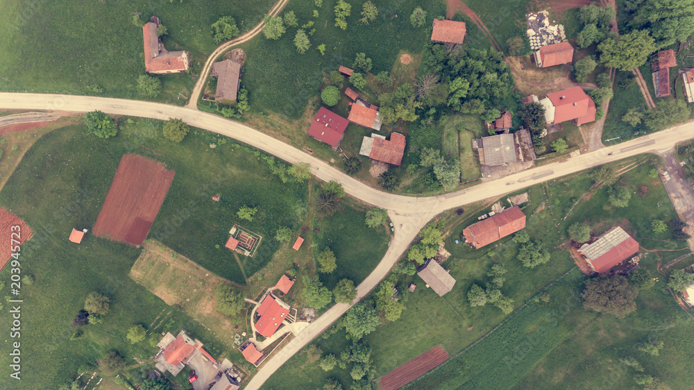 Drop down view of road junction surrounded with houses.